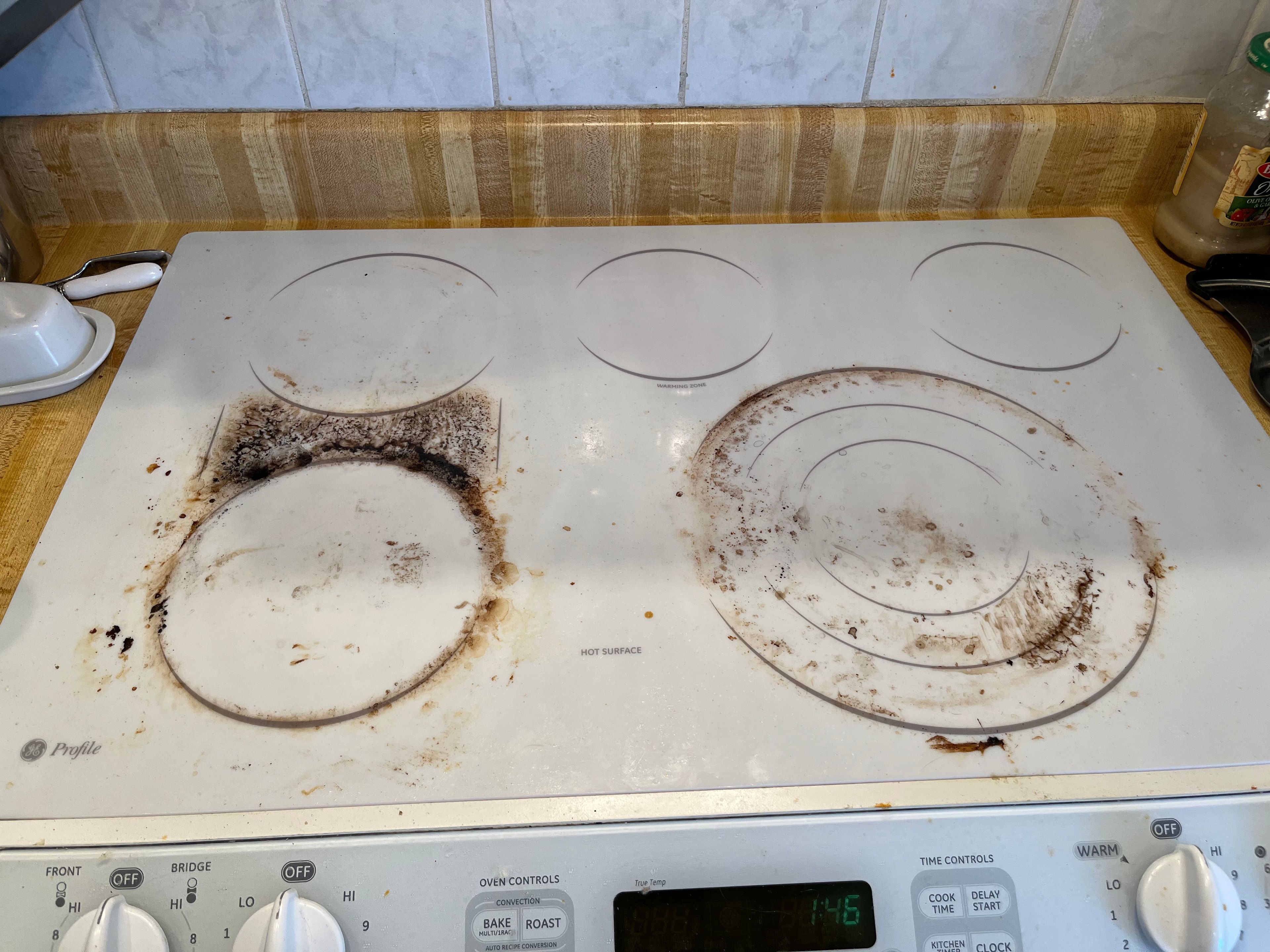 Kitchen stovetop before cleaning — burnt residue and grime